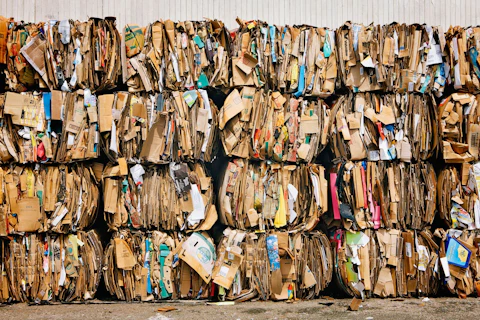 Stosy zużytych kartonowych opakowań przygotowanych do recyklingu.